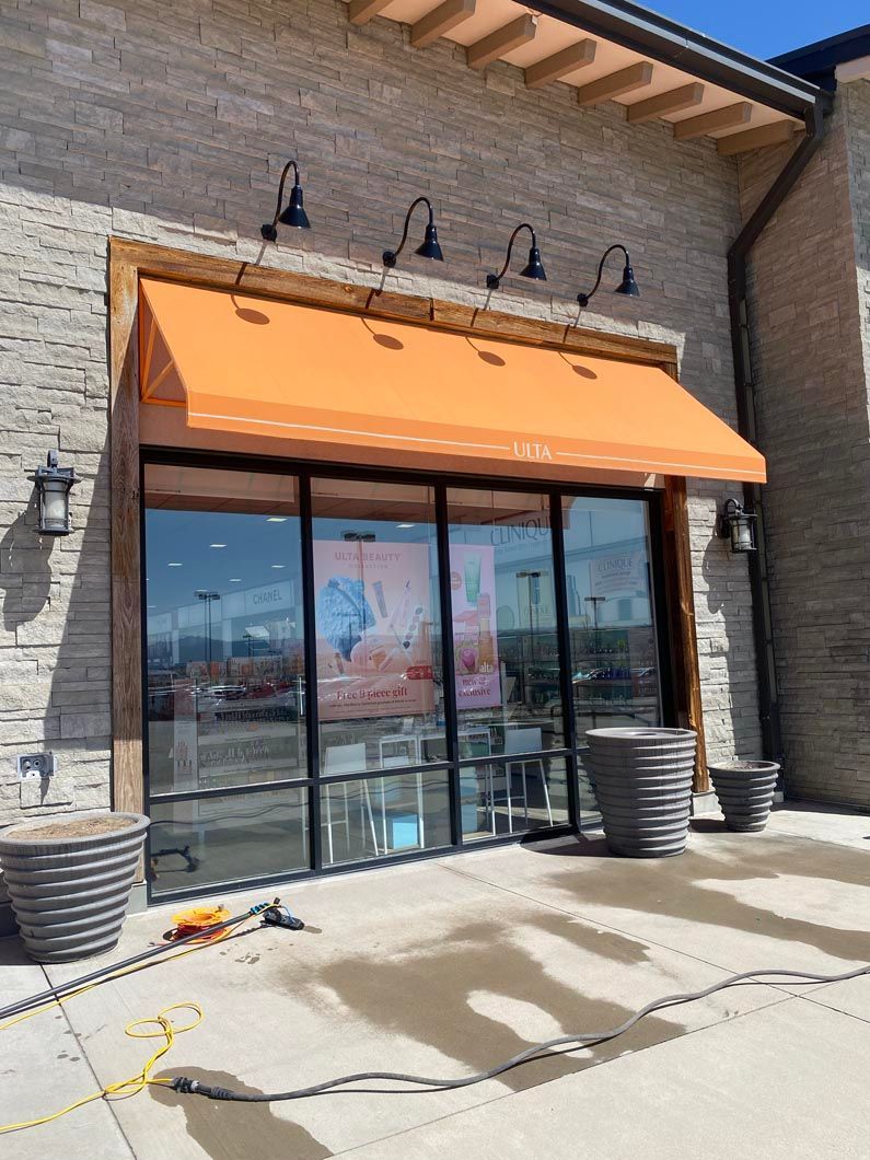 A store front with an orange awning over the door.