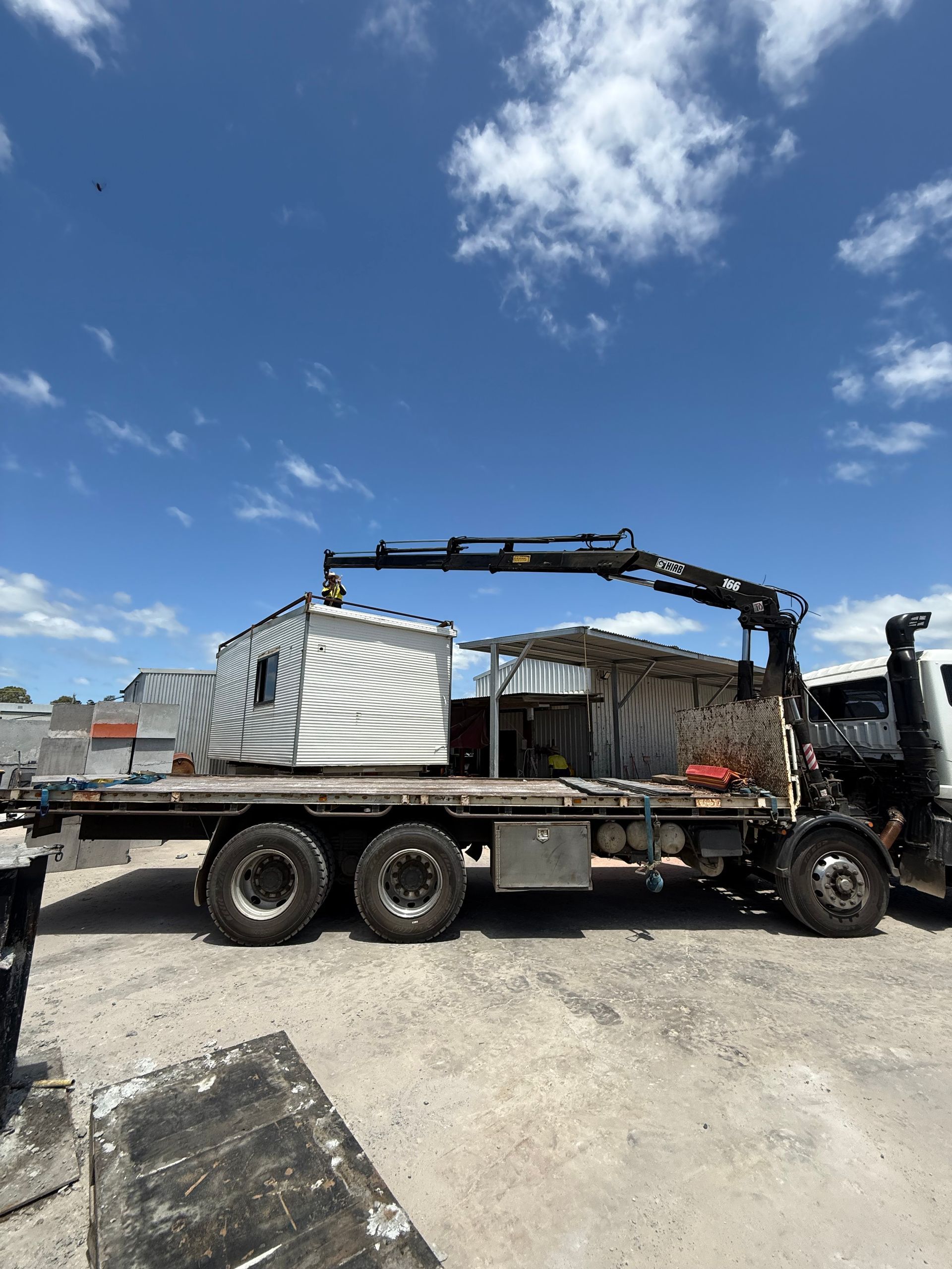 A Crane Truck is Moving a Container — Brodees Crane Trucks in Lismore, NSW