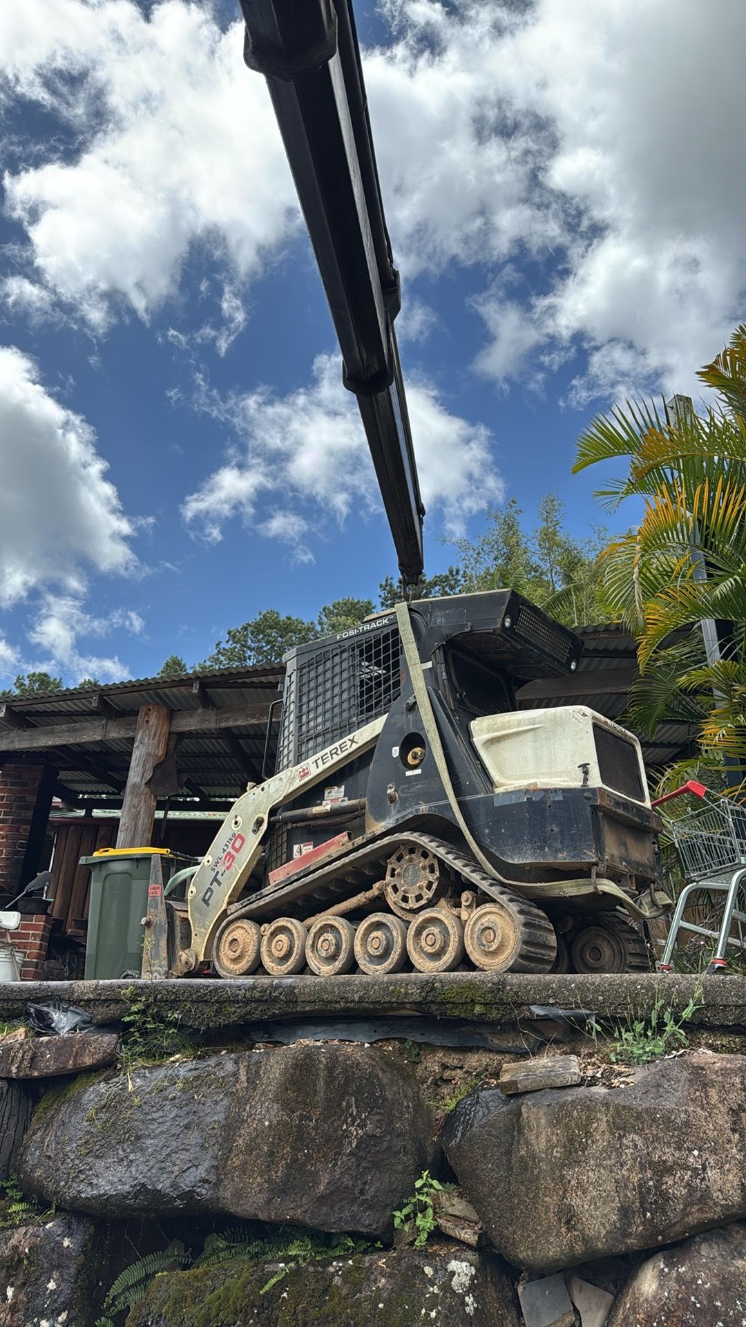 A Crane is Holding a Digger — Brodees Crane Trucks in Murwillumbah, NSW