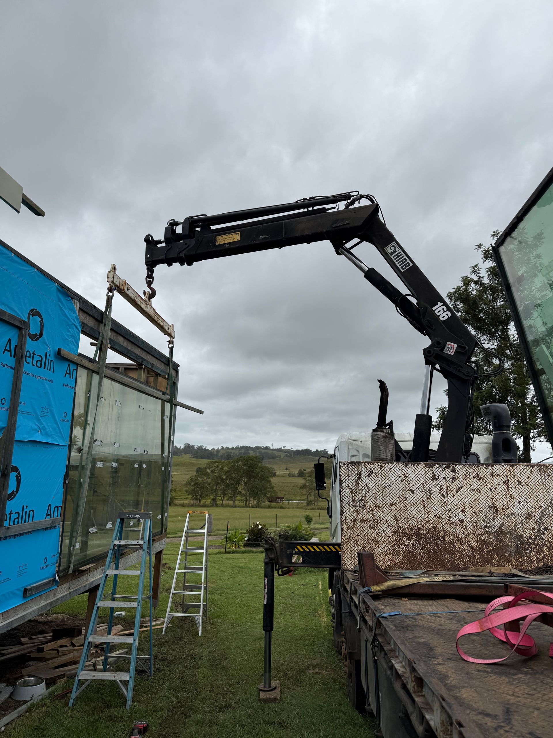 A Truck is Being Loaded With a Container in a Warehouse — Brodees Crane Trucks in Murwillumbah, NSW