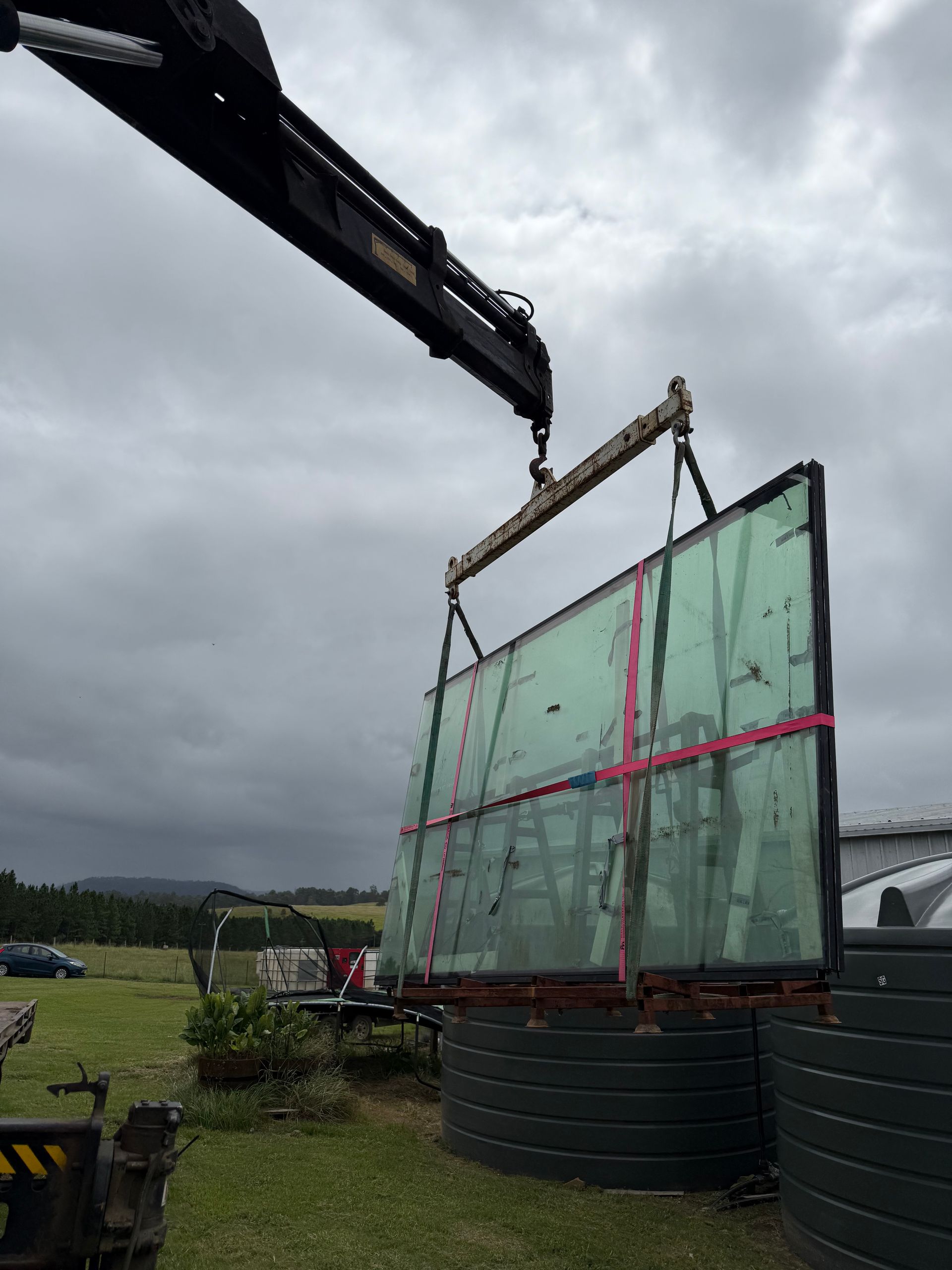 A Crane Truck is Moving Glass— Brodees Crane Trucks in Gold Coast, NSW