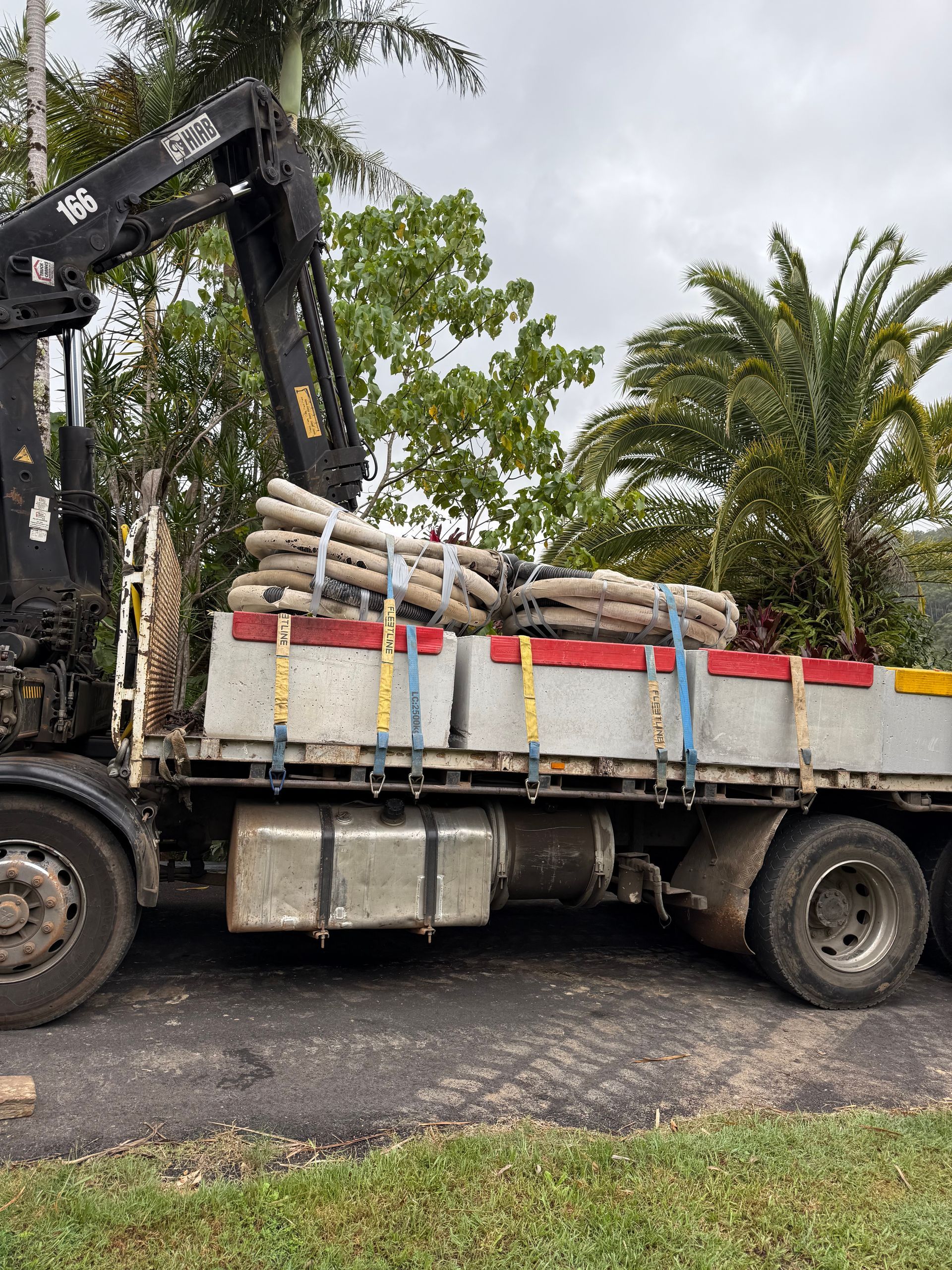 A Crane Truck has Concrete and Pipes on it's Trailer— Brodees Crane Trucks in Northern, NSW