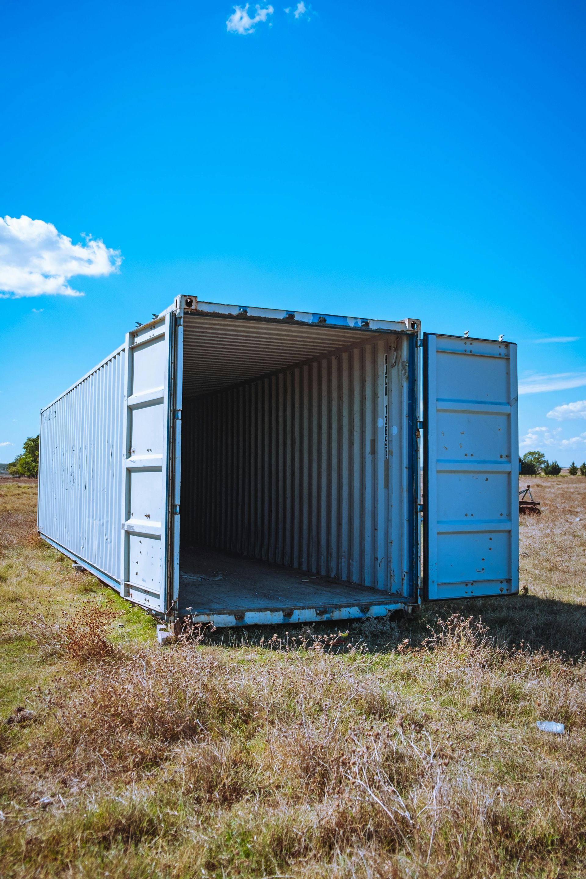 A Blue Shipping Container is Open in a Field — Brodees Crane Trucks in Murwillumbah, NSW