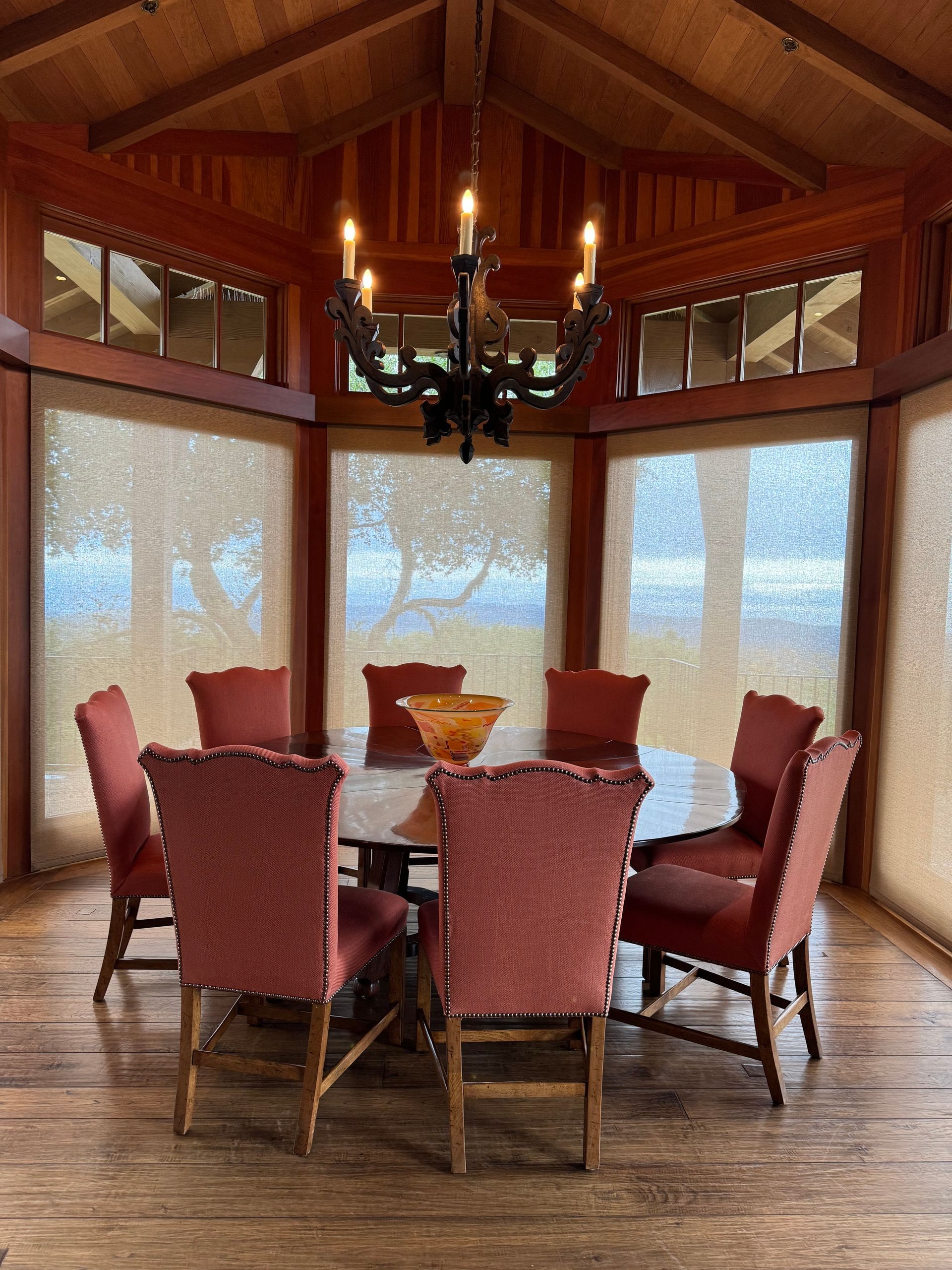 A lush green field with trees and mountains in the background