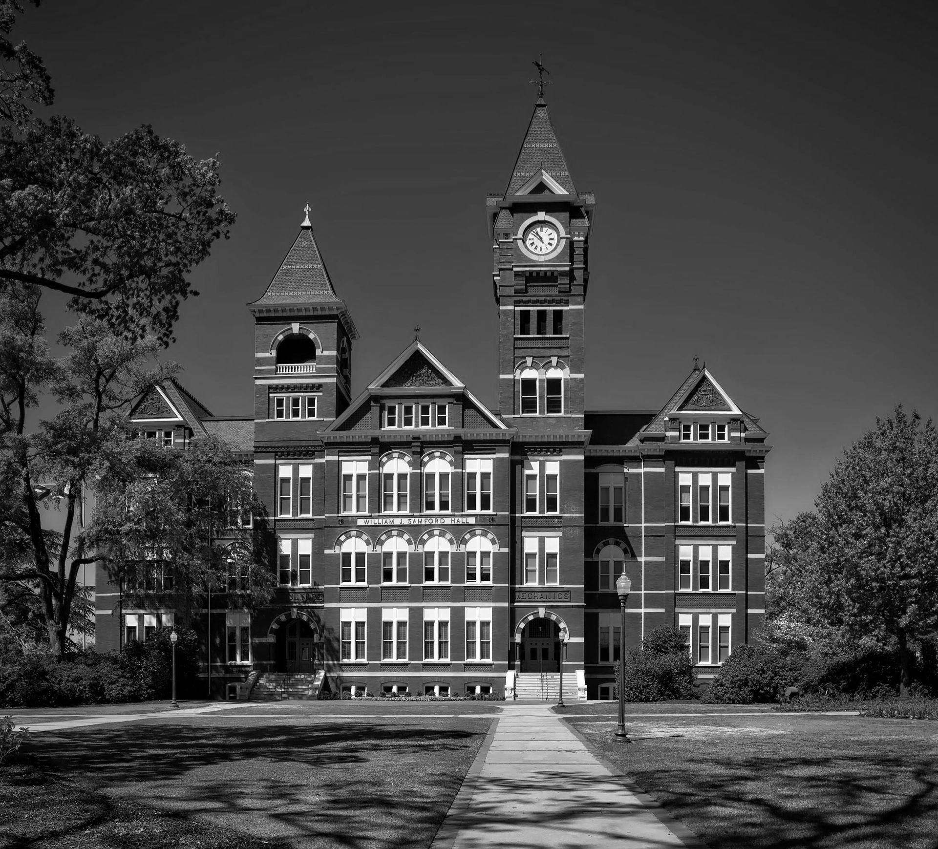 A black and white photo of a large brick building with a clock tower