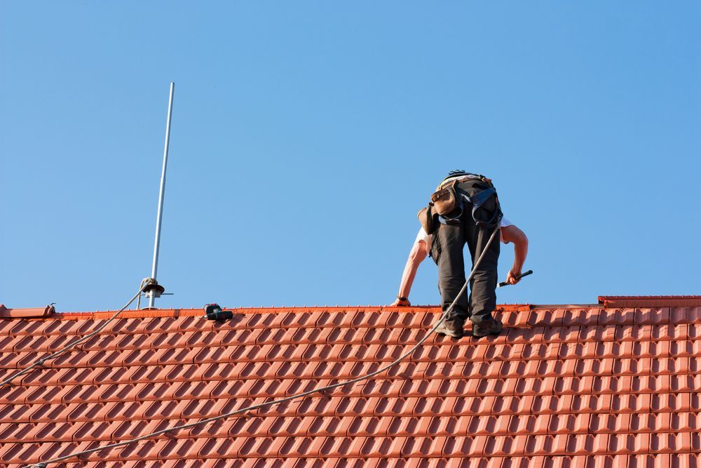 A Man is Working on the Roof of a House — Roofpoint In Kawungan, QLD