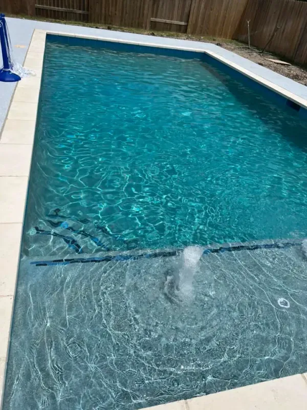 A large swimming pool with a fountain in the middle of it.