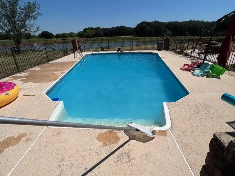 A large swimming pool with a fence around it