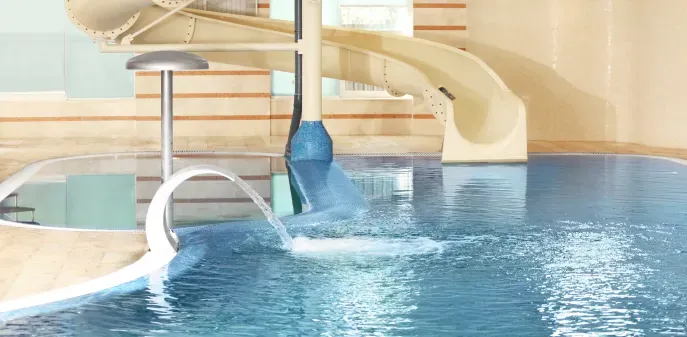 There is a water slide in the middle of the pool.