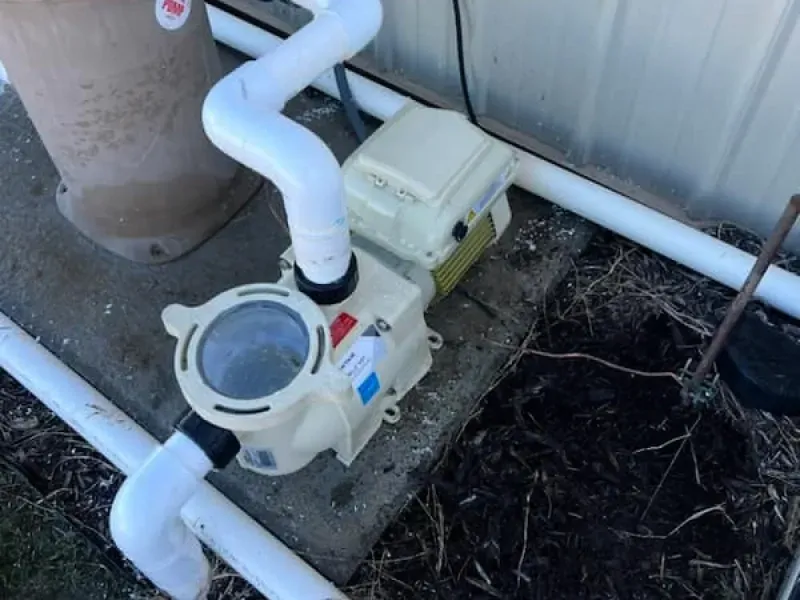 A swimming pool pump is sitting on the side of a building