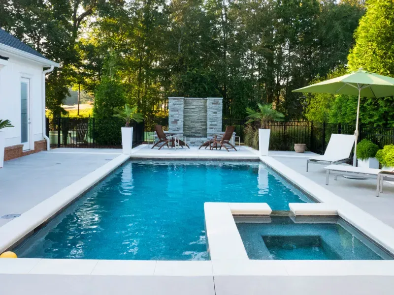 A large swimming pool with chairs and umbrellas around it