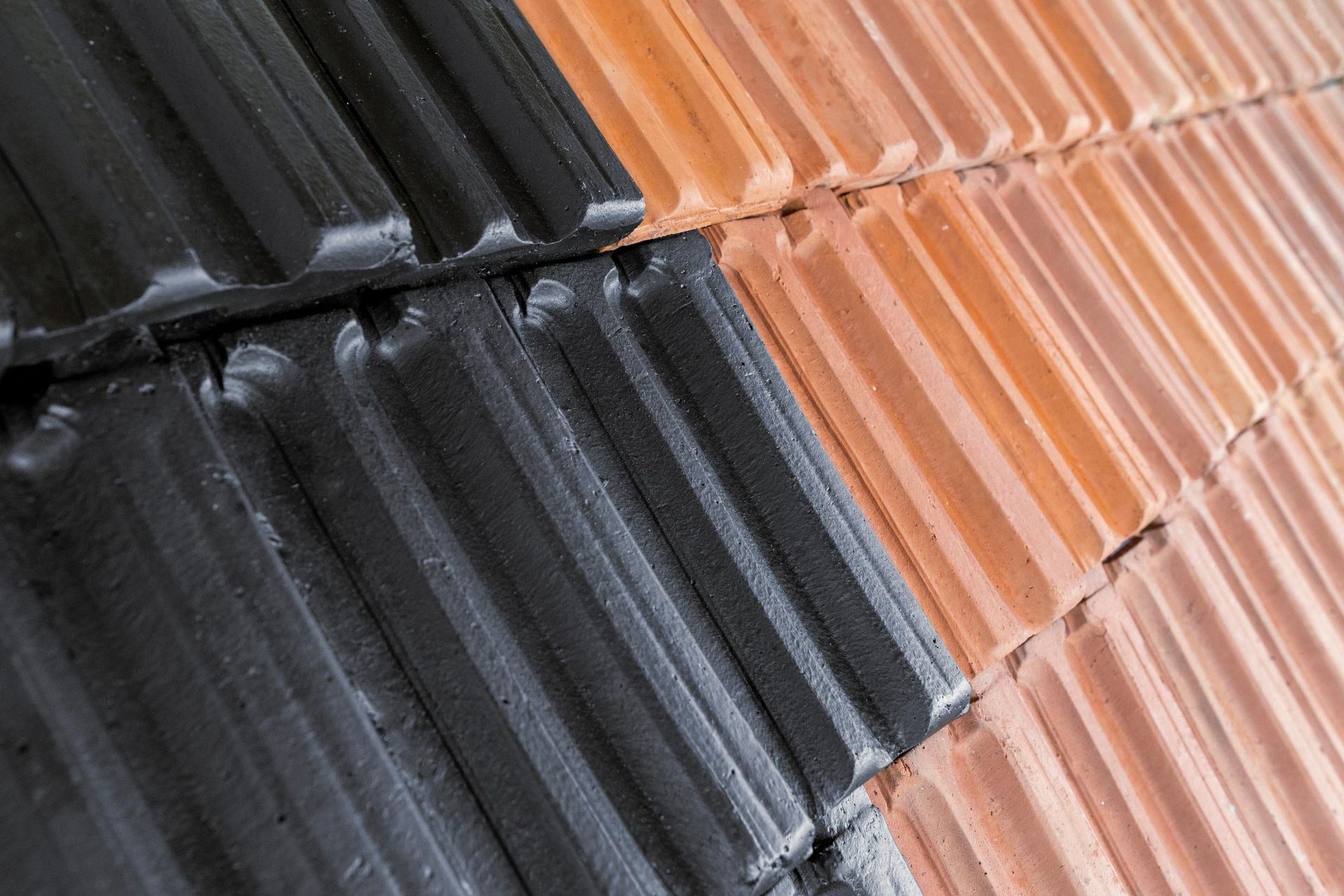 Black and terracotta roof tiles arranged diagonally. Black and terracotta roof tiles arranged diagonally.