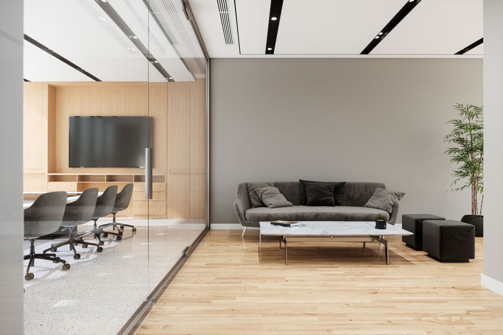 Modern office lounge area with a gray sofa, coffee table, and conference room visible through glass. Modern office lounge area with a gray sofa, coffee table, and conference room visible through glass.