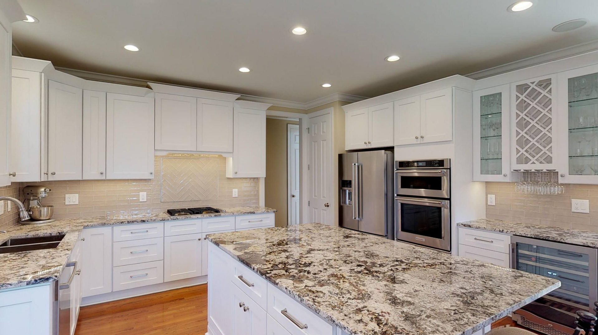 A kitchen with white cabinets and granite counter tops