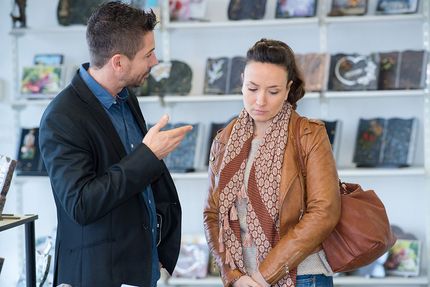 A man is talking to a woman in a store.