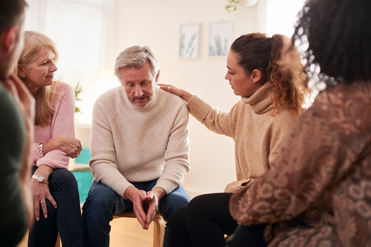 A group of people are sitting in a circle talking to each other.