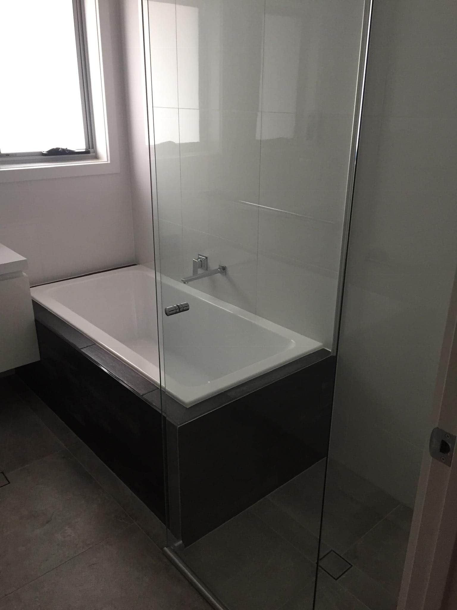 A Modern Bathroom With a White Bathtub — Rectified Edge Tiling & Bathroom Renovations in Jamison Centre, ACT