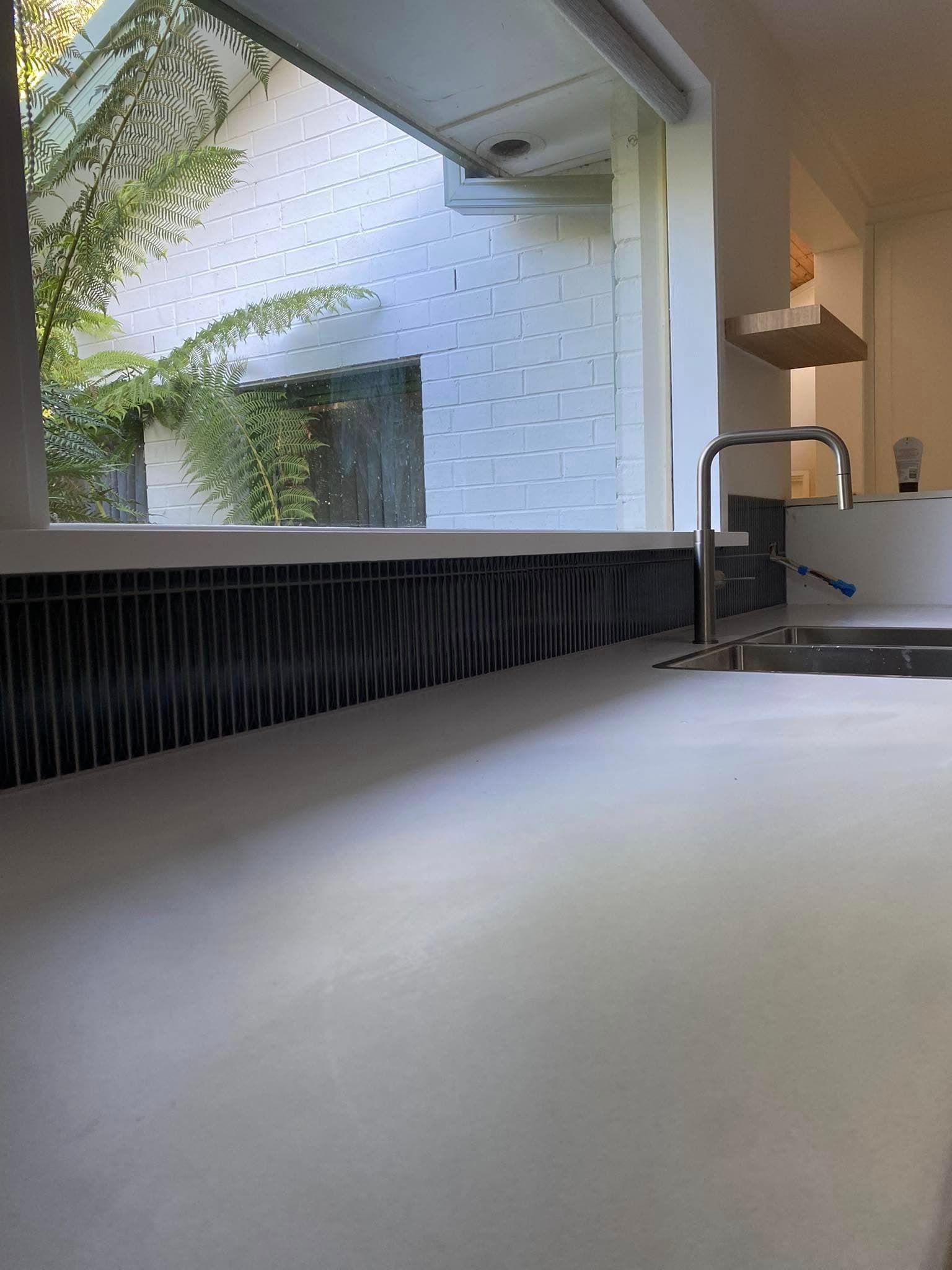 A Kitchen Counter With a Light Surface — Rectified Edge Tiling & Bathroom Renovations in Jamison Centre, ACT