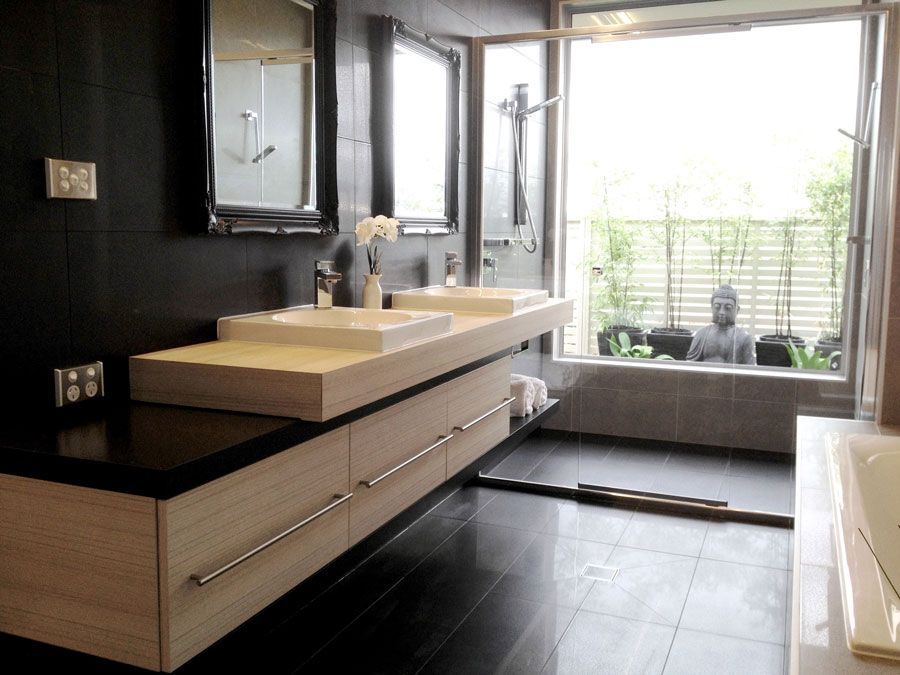 Modern bathroom with floating vanity, black and white colour scheme, large window with Buddha statue. — Rectified Edge Tiling & Bathroom Renovations in Fyshwick, ACT