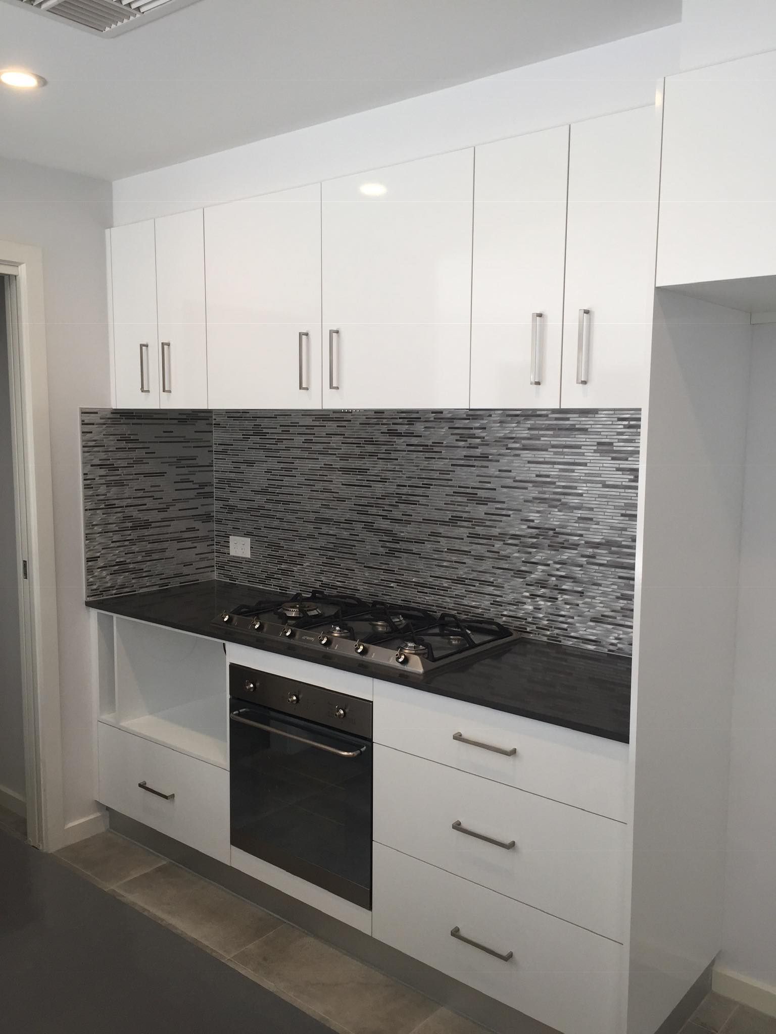 White Kitchen Cabinets, Black Countertop — Rectified Edge Tiling & Bathroom Renovations in Yass, NSW