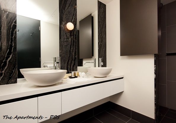 Modern bathroom with white sinks, dark marble accent wall, and grey walls. — Rectified Edge Tiling & Bathroom Renovations in Batemans Bay, NSW