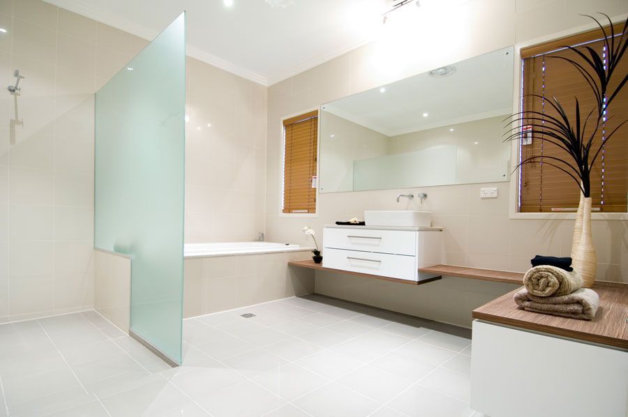 Modern bathroom with frosted glass shower, white vanity, large mirror, and neutral tones. — Rectified Edge Tiling & Bathroom Renovations in Fyshwick, ACT