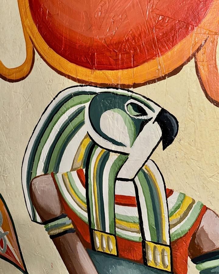 Egyptian god Horus with hawk head, beneath orange sun.