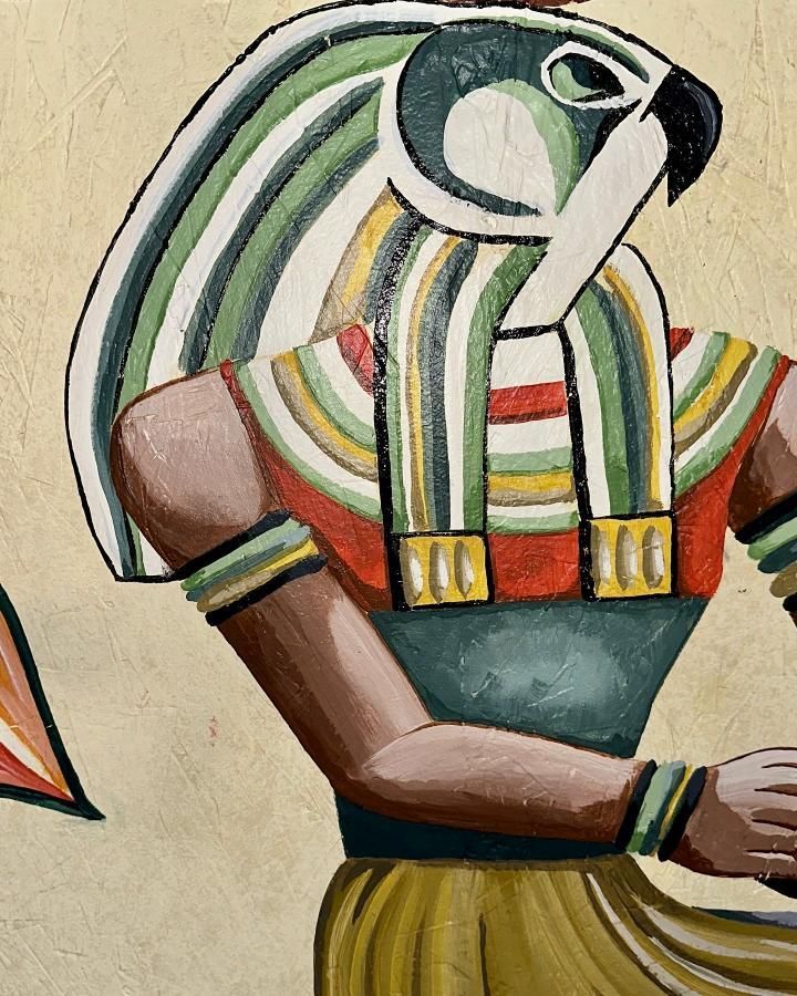 Egyptian deity with falcon head, wearing colorful collar and cuffs, set against a light yellow background.