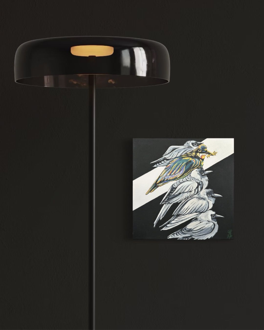 Black floor lamp and abstract bird painting on a black wall.