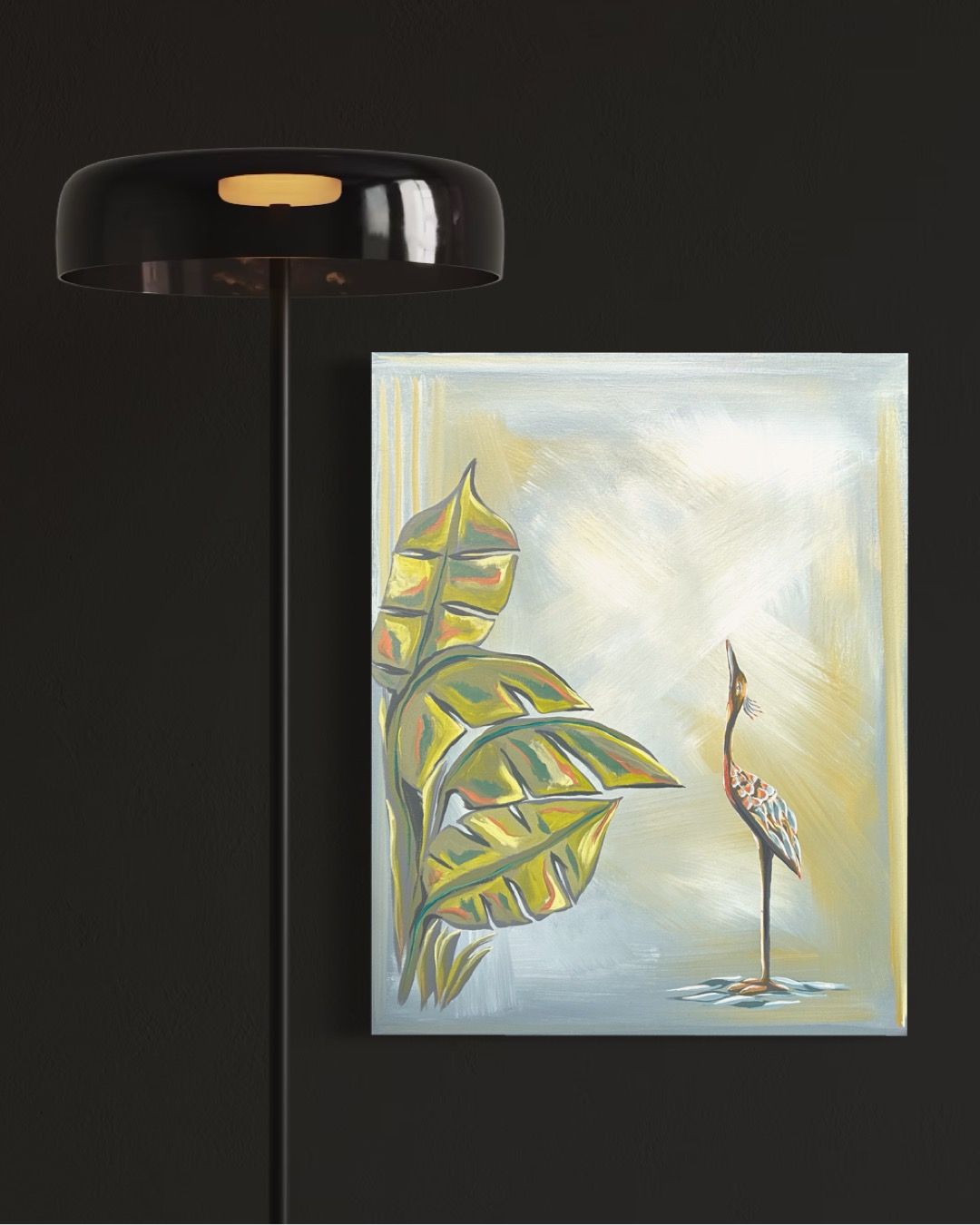 Black lamp next to a painting of a heron and leaves.
