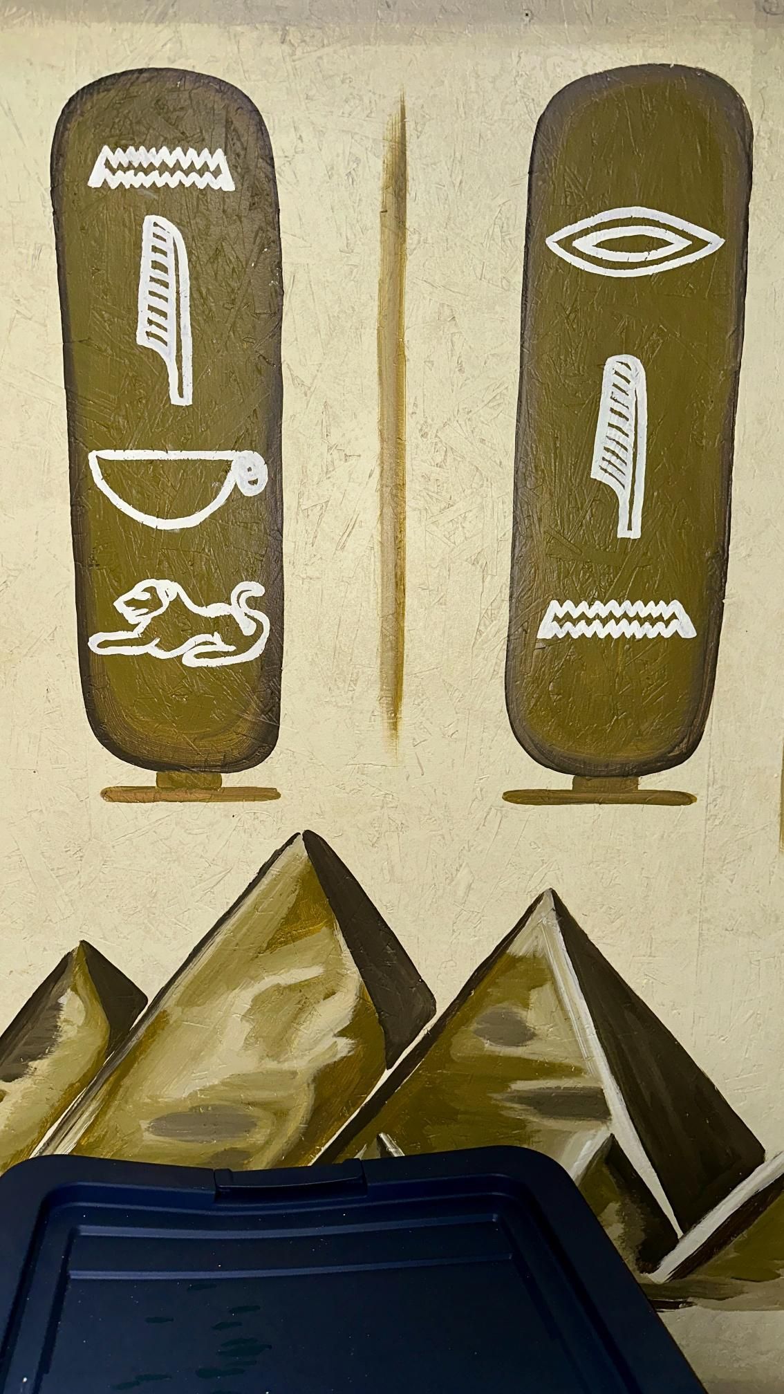 Ancient Egyptian cartouches flank a central line; beneath are pyramids.