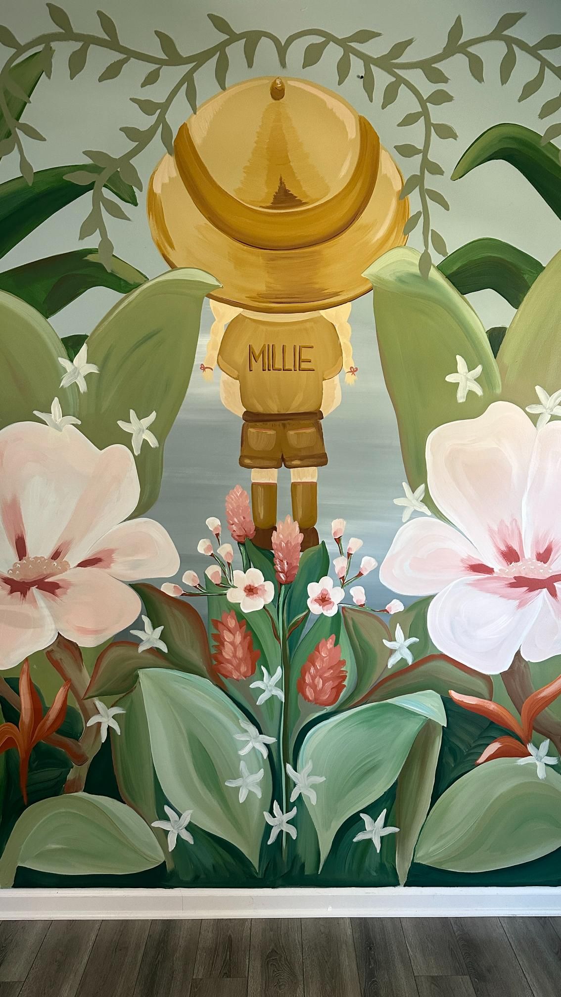 Mural of a figure wearing safari hat and clothes, surrounded by large flowers and foliage.