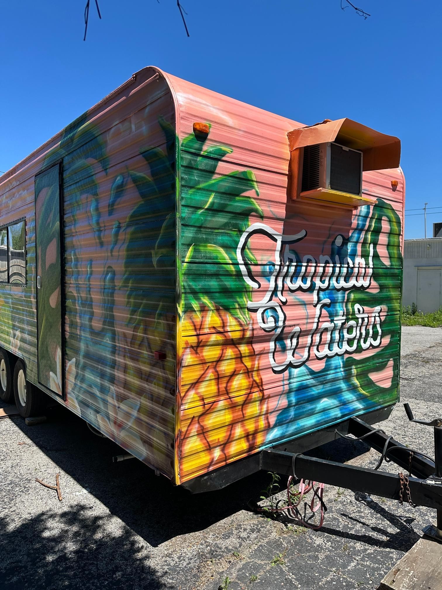 Colorful food trailer with pineapple and tropical scene; 