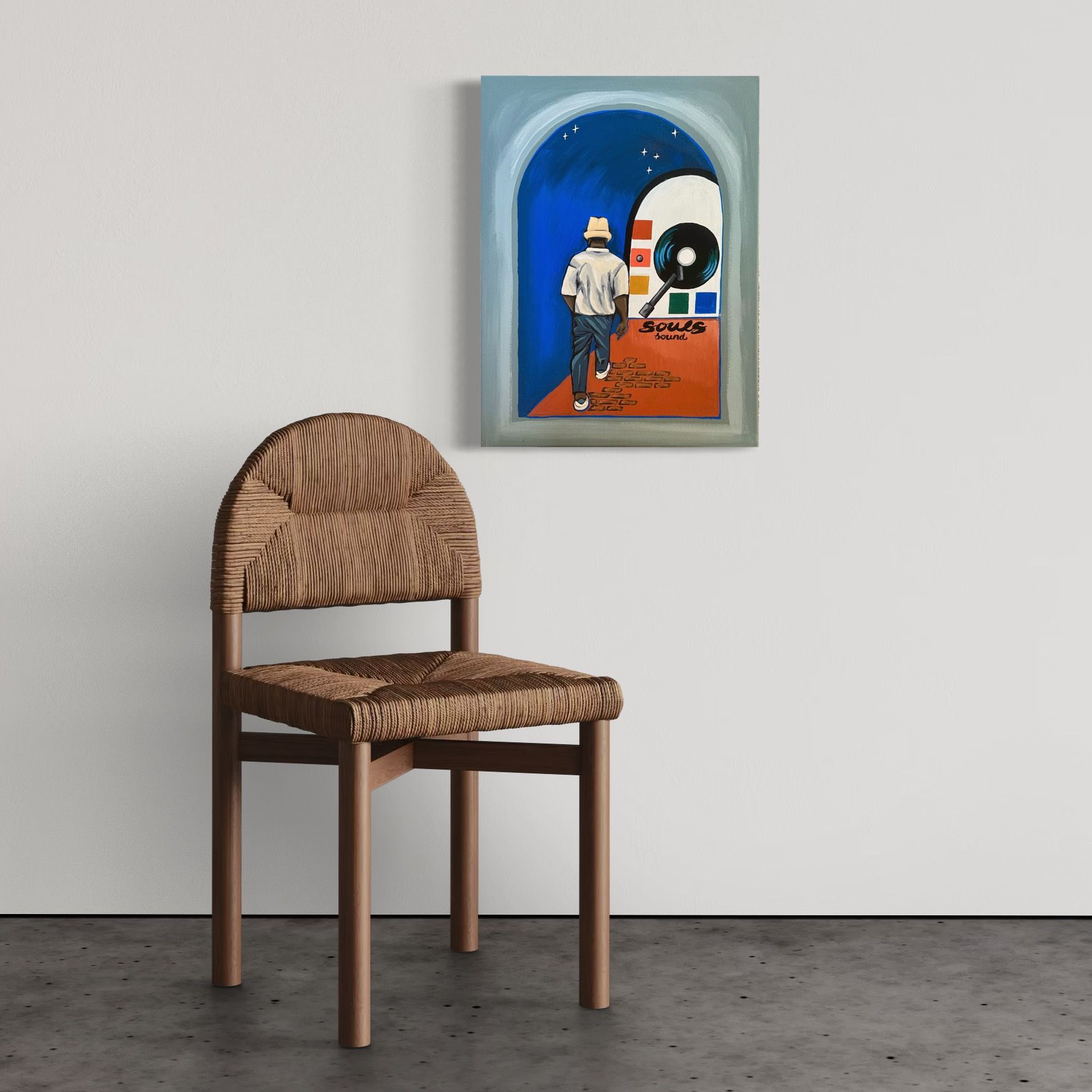 Chair in front of wall with framed art of person walking toward a retro jukebox.
