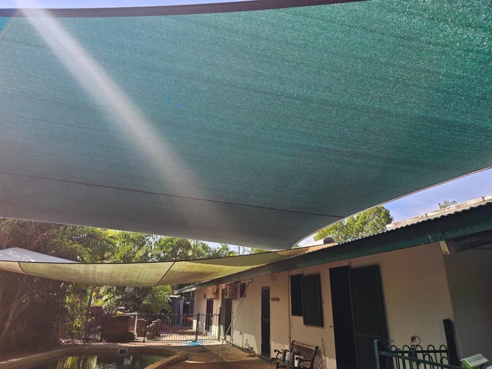 A Large Green Shade Sail Is Hanging Over A House — All Car Upholstery In Pinelands, NT