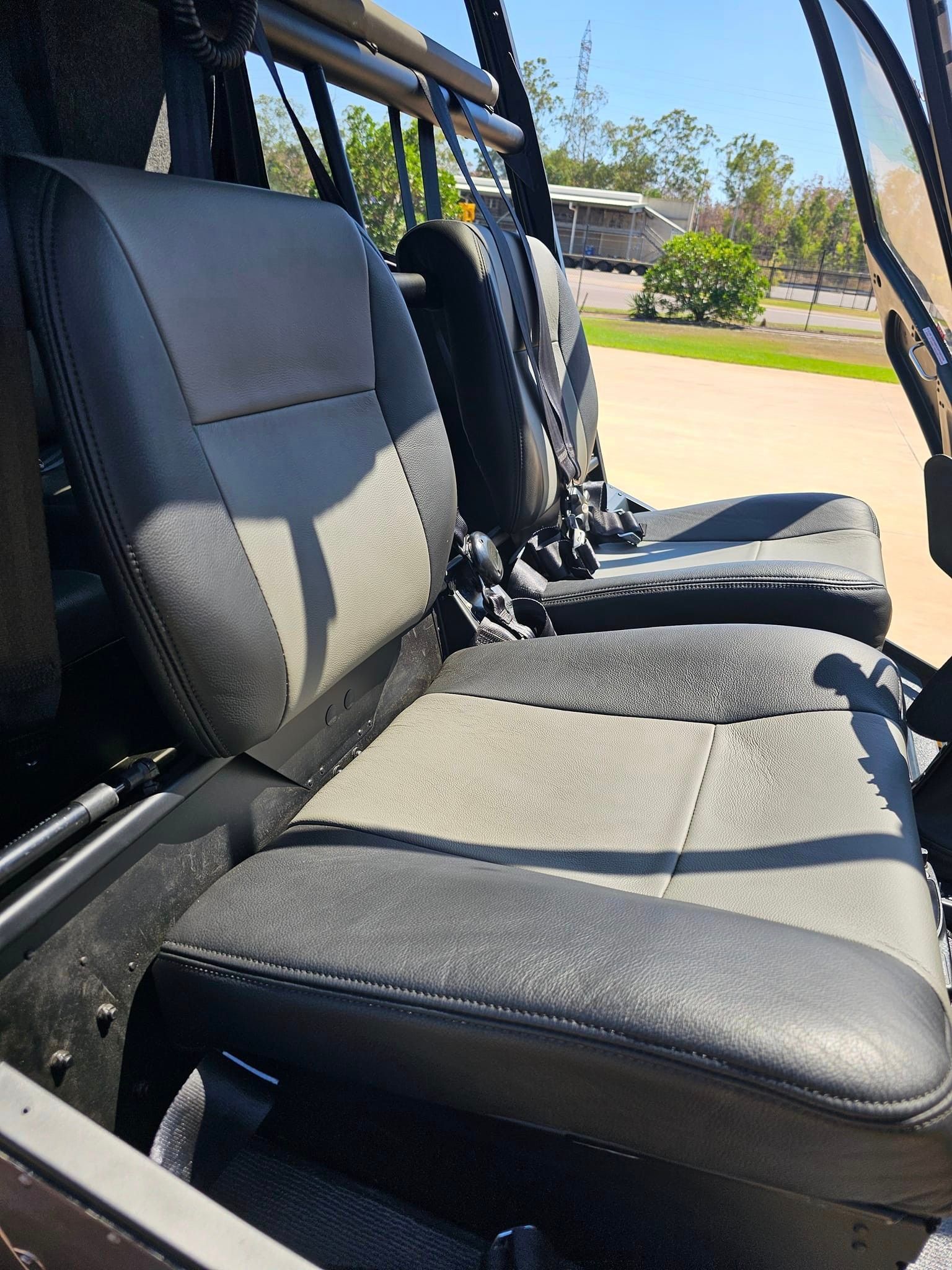 A Group Of Brown Seats With Black Belts Are Sitting On A Table — All Car Upholstery In Pinelands, NT