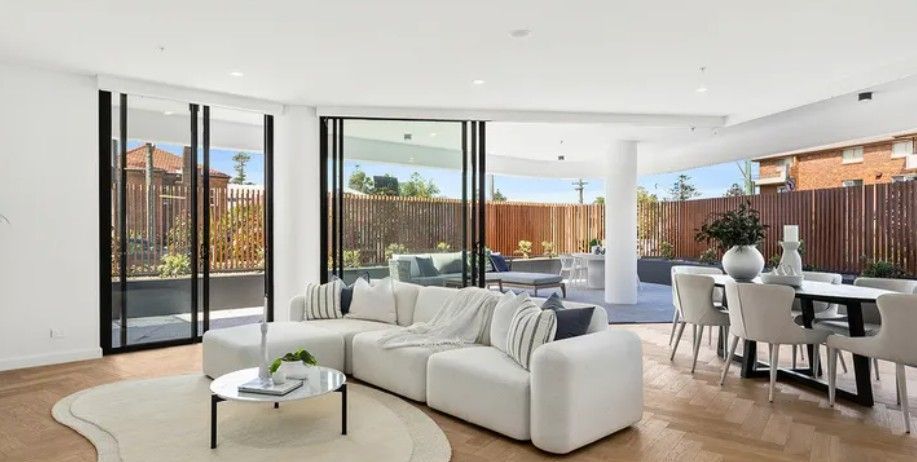 A living room with a white couch and large doors leading to an outdoor area — Commercial Painting Group in Kembla Grange, NSW