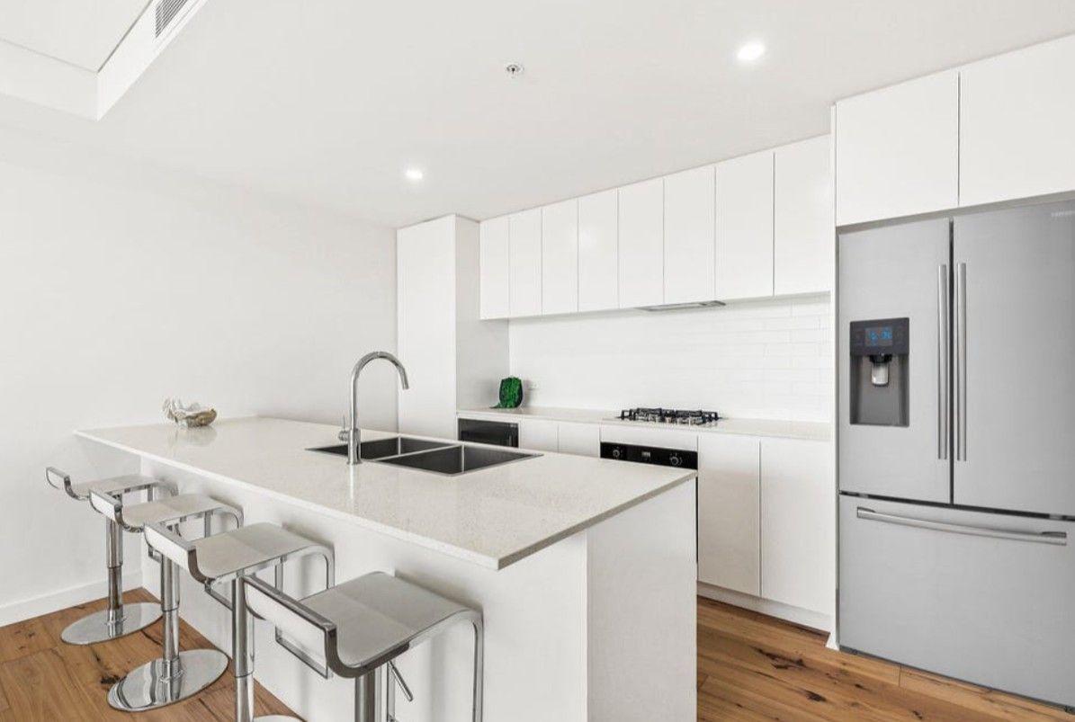 A kitchen with a white bench, silver chairs and white cupboards — Commercial Painting Group in Kembla Grange, NSW