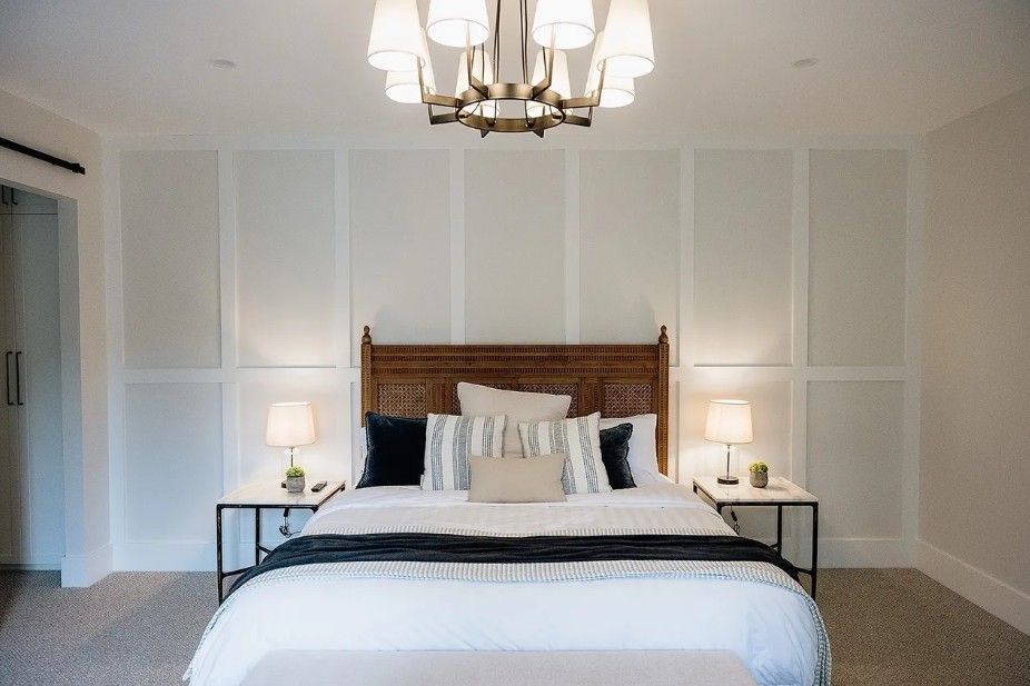 A bedroom with a bed, wooden bed head, bedside tables and a light hanging — Commercial Painting Group in Kembla Grange, NSW