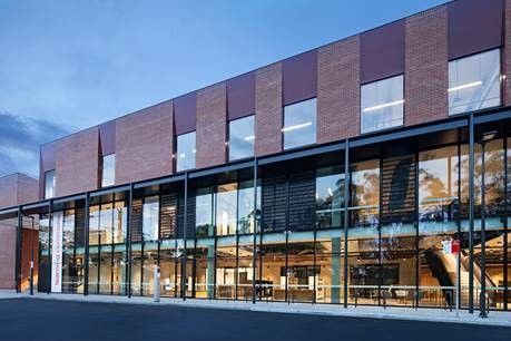 The outside of a building with red walls and lots of windows — Commercial Painting Group in Kembla Grange, NSW