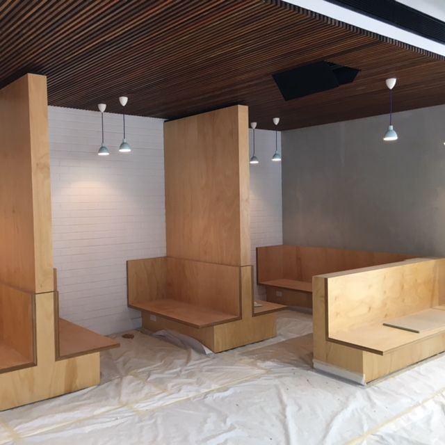 Wooden bench seats and downlights hanging from the roof — Commercial Painting Group in Kembla Grange, NSW