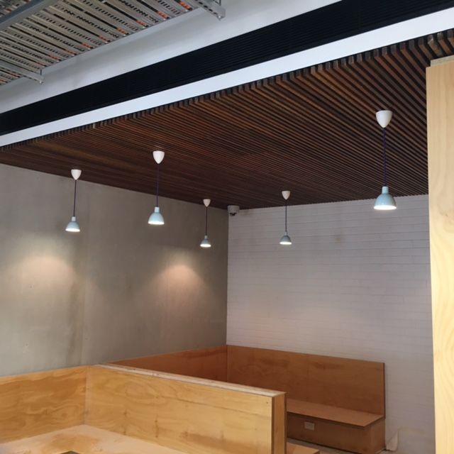 Lights hanging from the celing above wooden tables — Commercial Painting Group in Kembla Grange, NSW