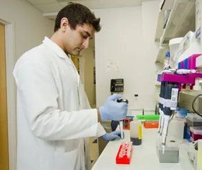 A man in a lab coat is working in a laboratory.