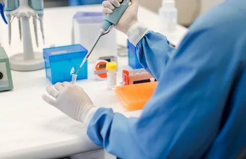 A scientist is using a pipette in a laboratory.