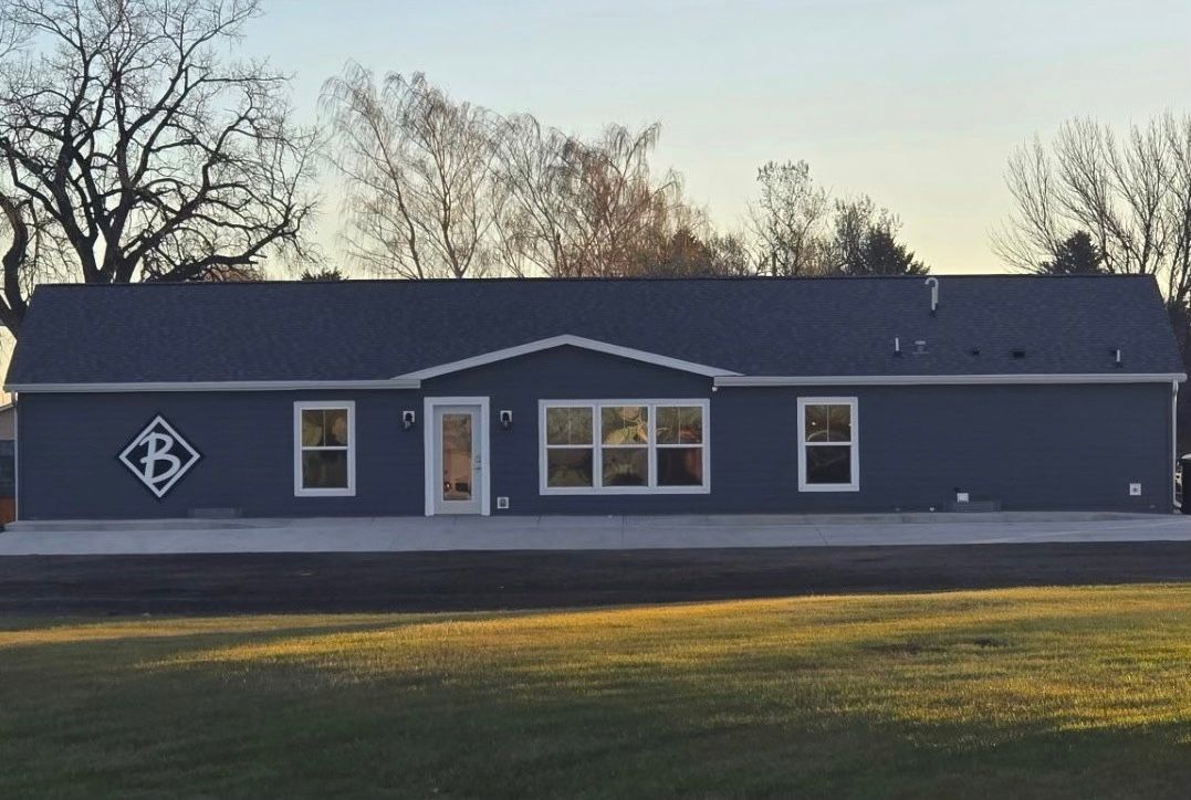 A man and two children are standing in a hallway holding hands.