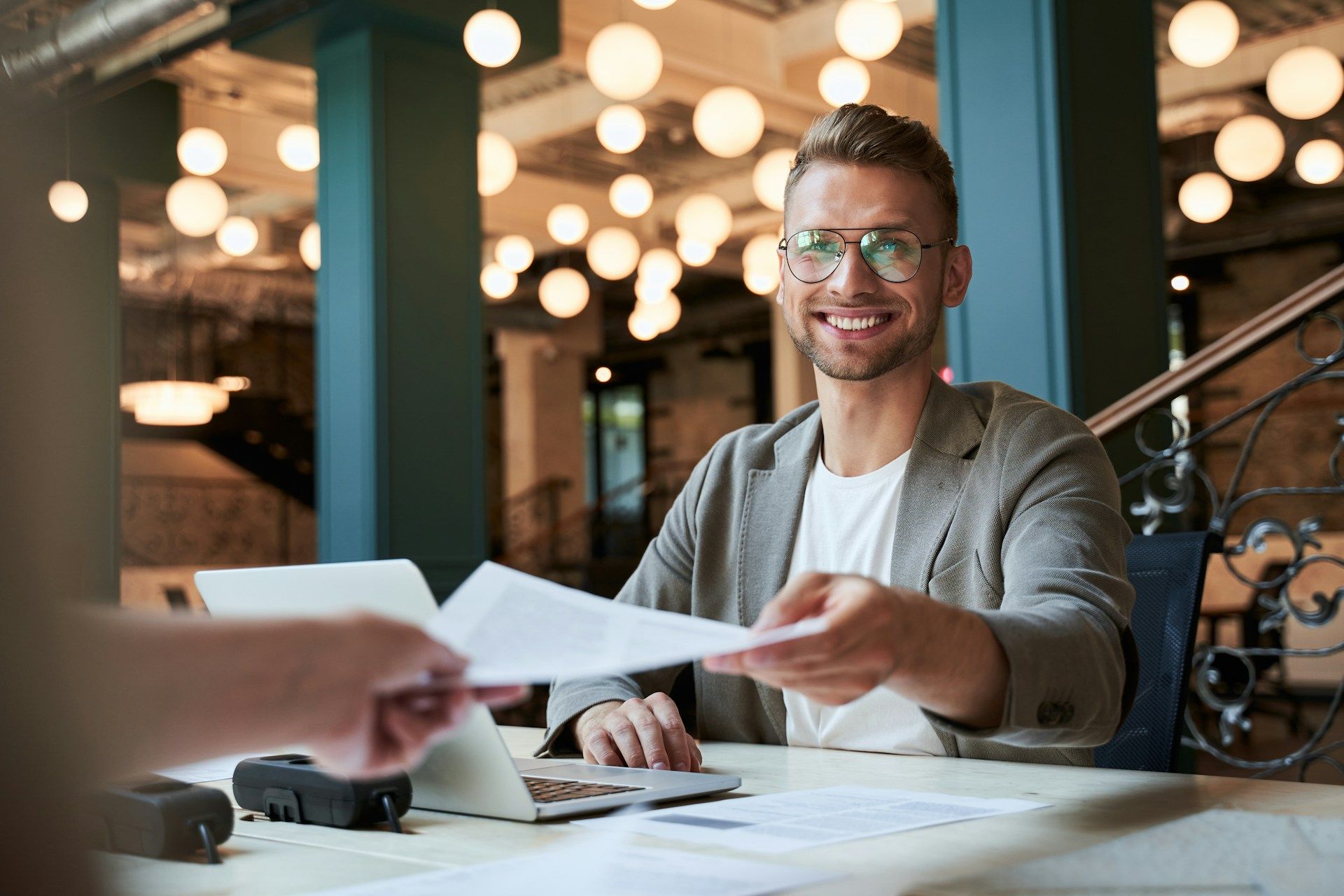 Two young boys are laying on the grass and talking to each other.