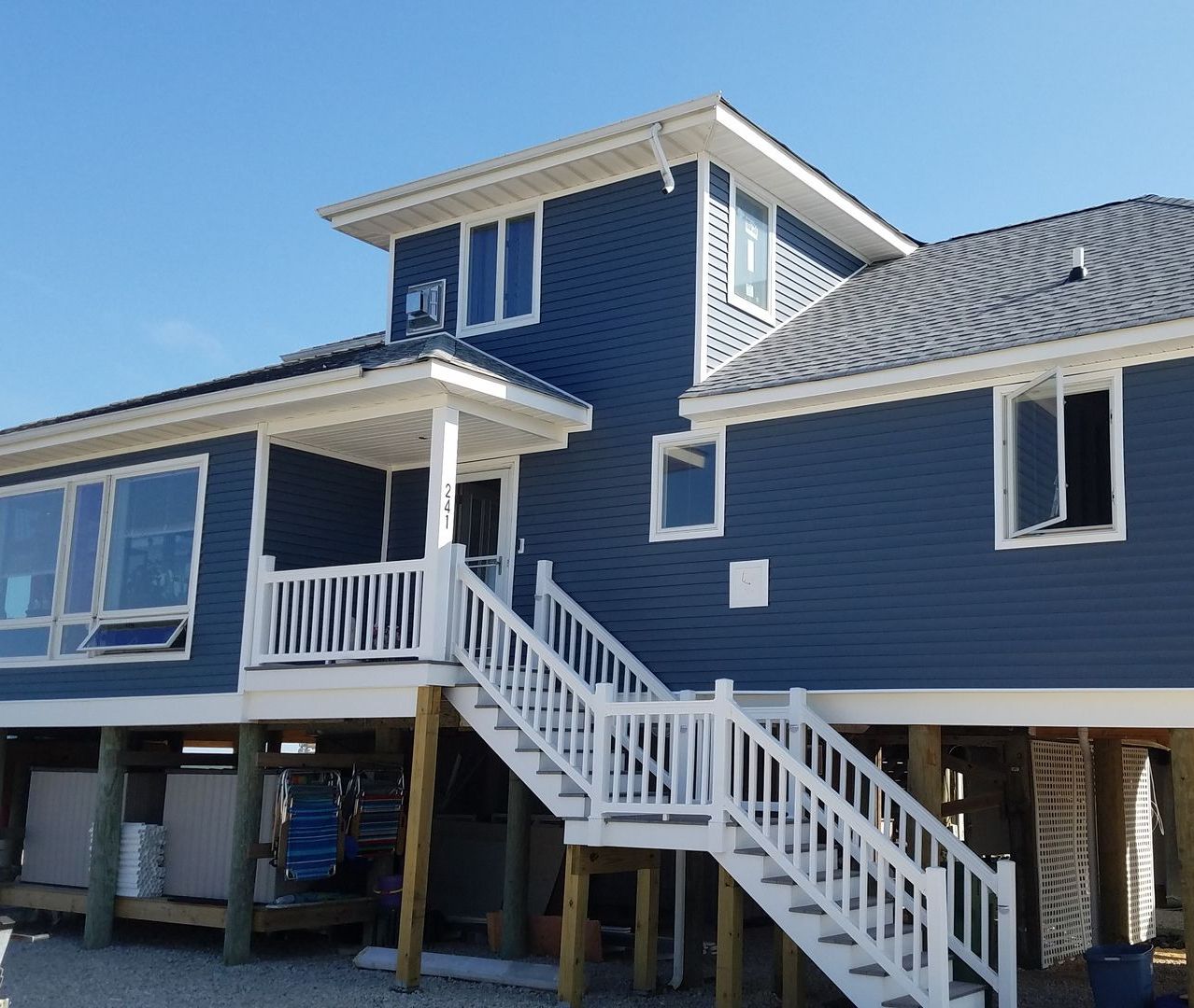 A blue house with white stairs leading up to it