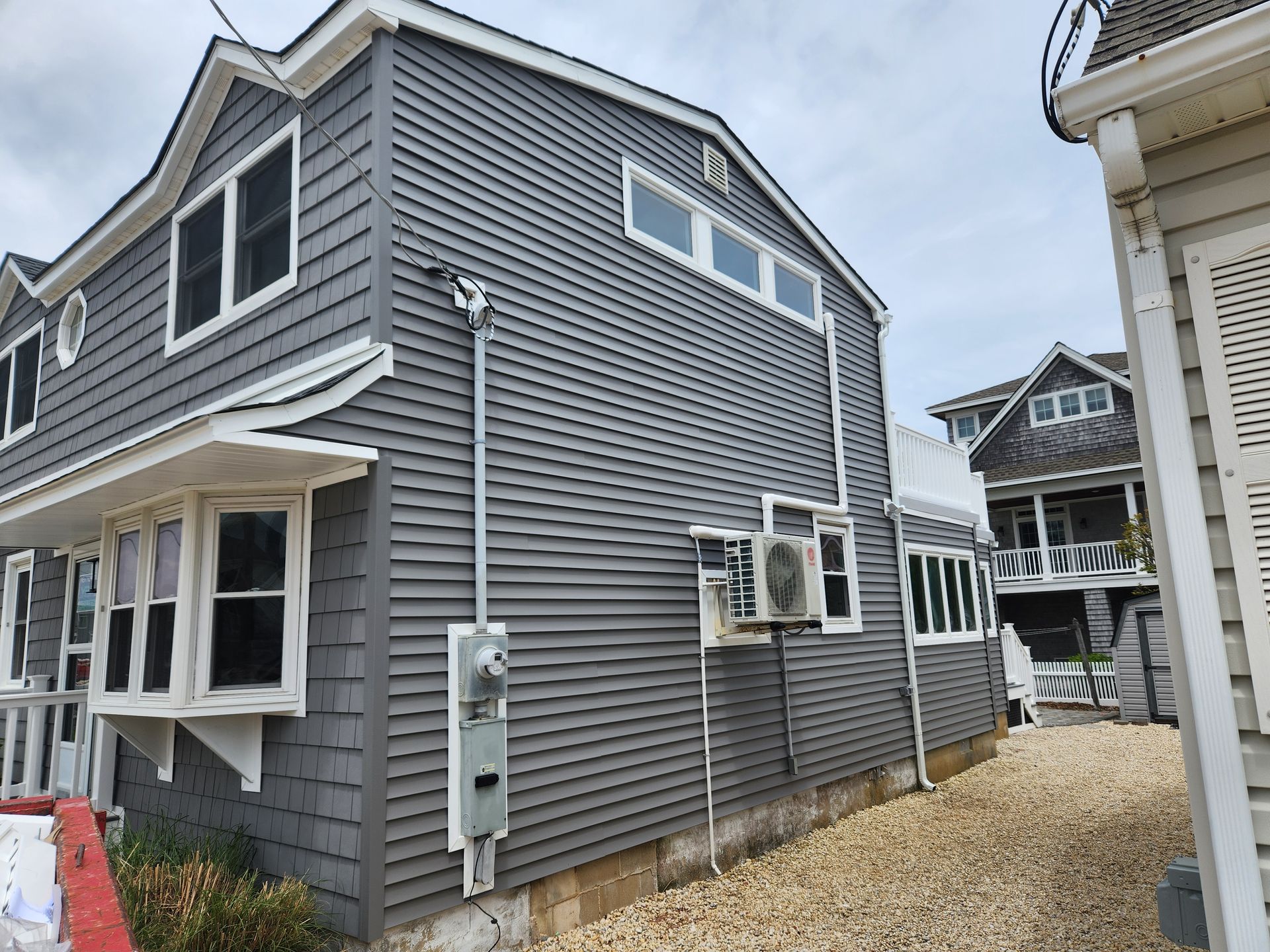 A gray house with a white trim and a lot of windows