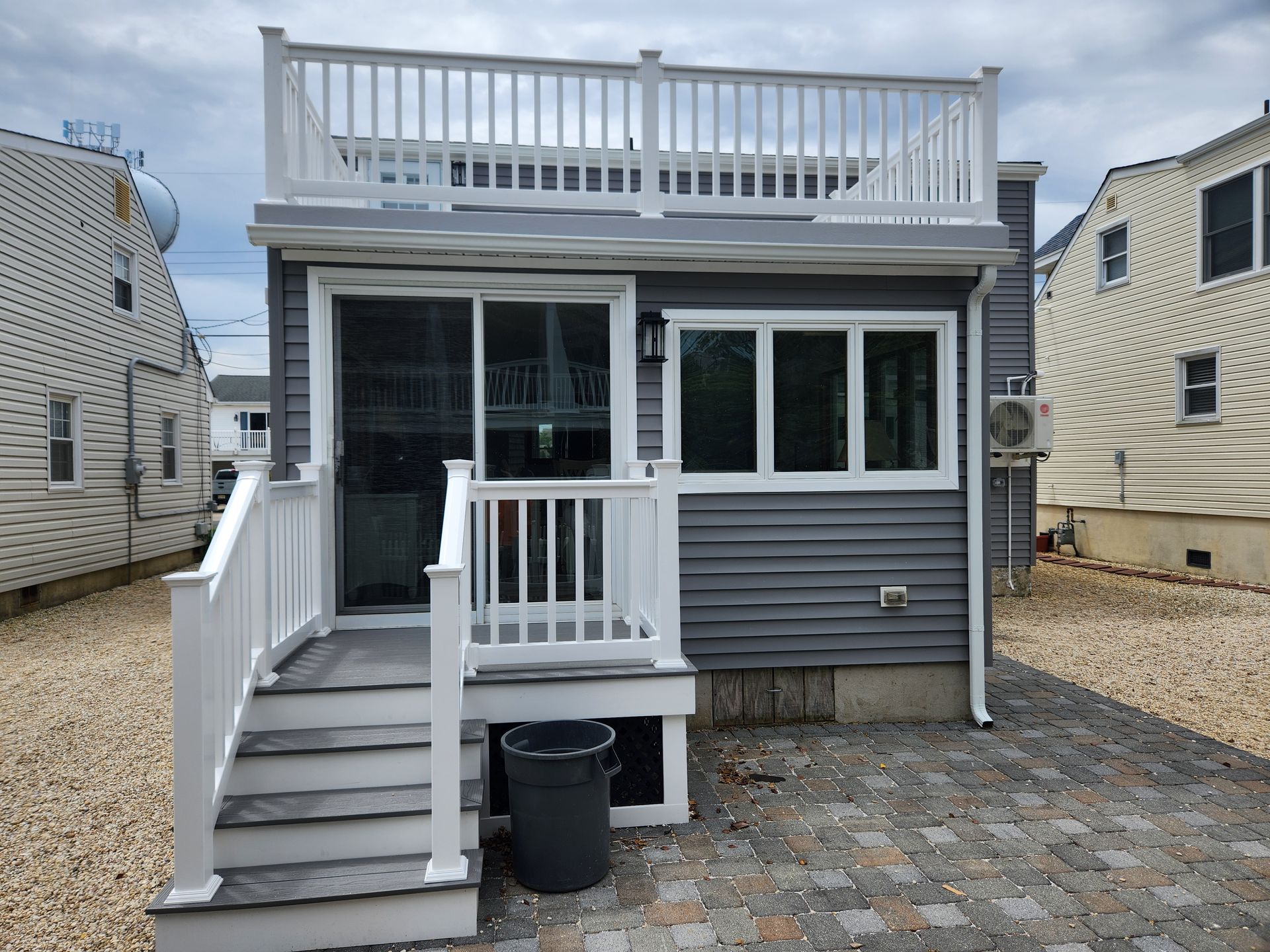 A small house with a white deck and stairs
