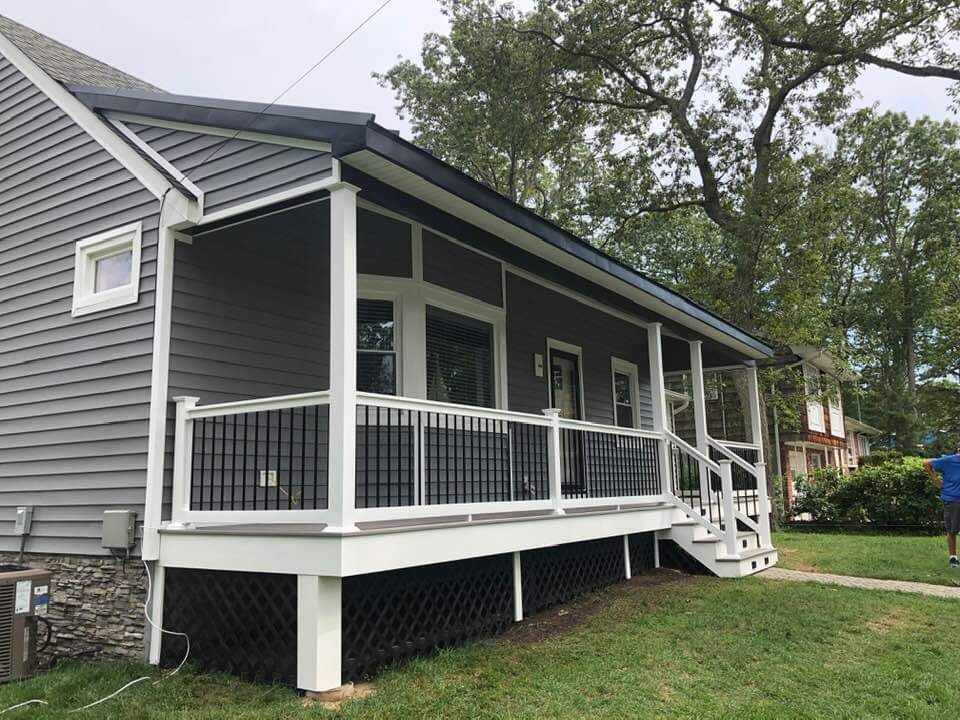 A house with a large porch and stairs on the side of it.